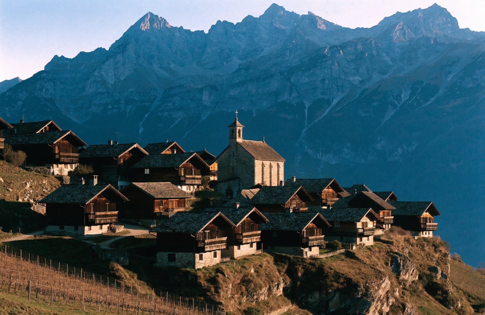 Village valaisan traditionnel sur un coteau ensoleillé, au-dessus des vignes